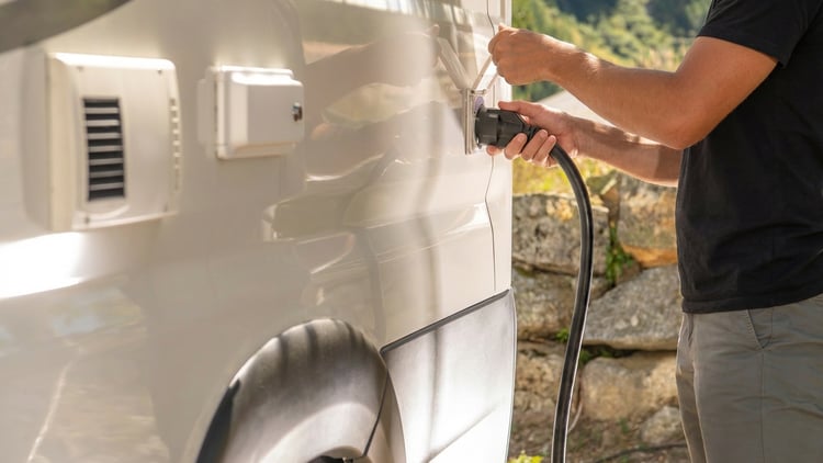 a man plugging his rv into a shore power hookup